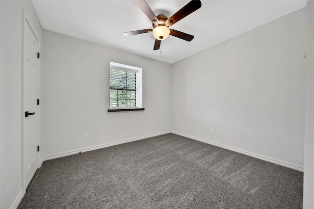 spare room featuring ceiling fan and dark colored carpet