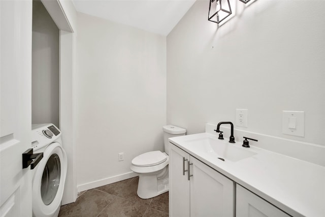 bathroom featuring tile patterned floors, toilet, vanity, and washer / dryer