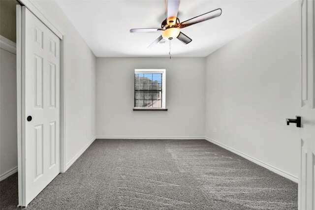 unfurnished bedroom with ceiling fan and dark carpet