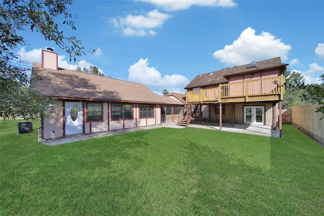 rear view of house featuring a wooden deck, a yard, and a patio