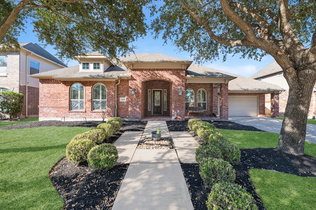 view of front of house featuring a garage and a front lawn