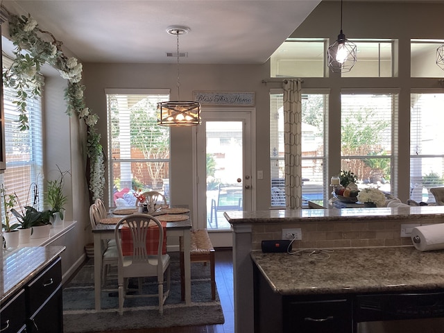 kitchen featuring an inviting chandelier, decorative light fixtures, dark hardwood / wood-style floors, and stone countertops