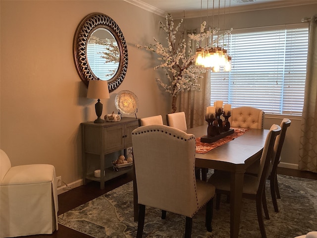 dining area with dark wood-type flooring and crown molding