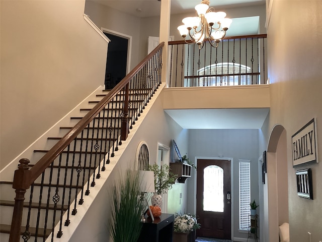 entrance foyer featuring a towering ceiling and an inviting chandelier