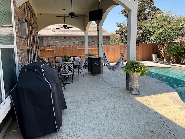 view of patio featuring area for grilling, ceiling fan, a fenced in pool, and central AC unit