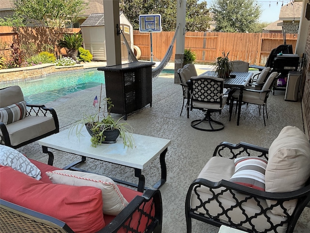 view of patio / terrace with a shed and a fenced in pool