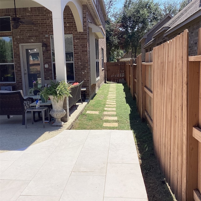 view of yard with ceiling fan and a patio