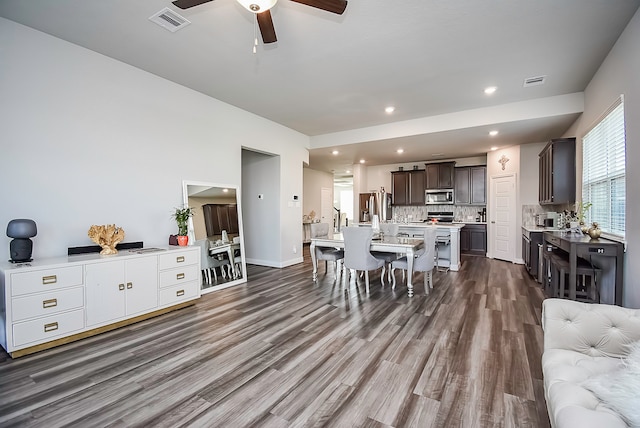 dining space with dark wood-type flooring and ceiling fan