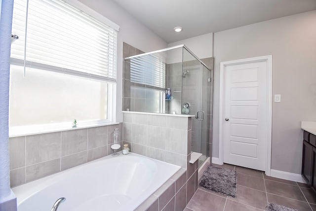 bathroom with vanity, independent shower and bath, plenty of natural light, and tile patterned flooring