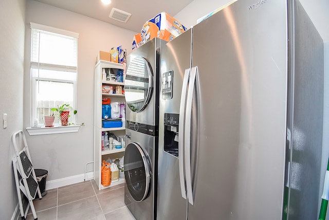 washroom featuring light tile patterned flooring and stacked washer and clothes dryer