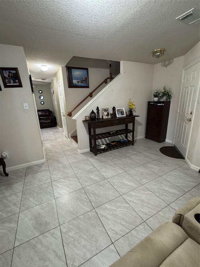 hallway with light tile patterned flooring and a textured ceiling