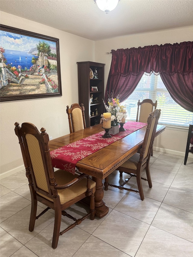 tiled dining space featuring a textured ceiling