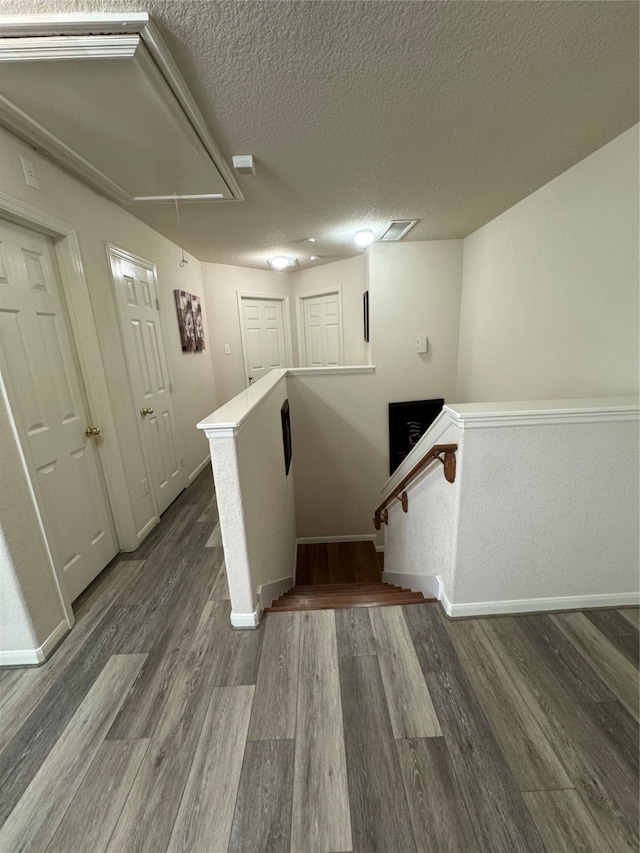 staircase with hardwood / wood-style flooring and a textured ceiling