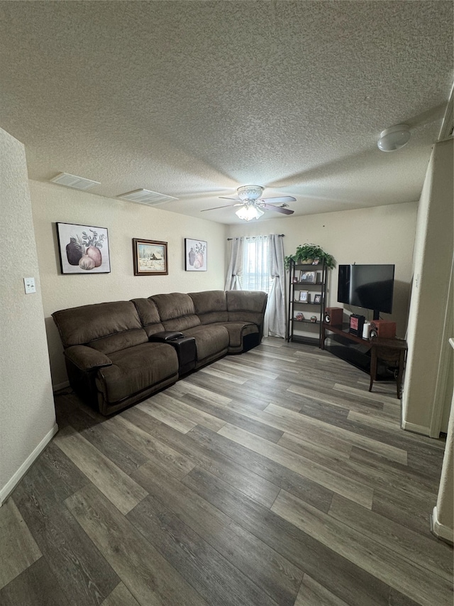 living room featuring ceiling fan, wood-type flooring, and a textured ceiling