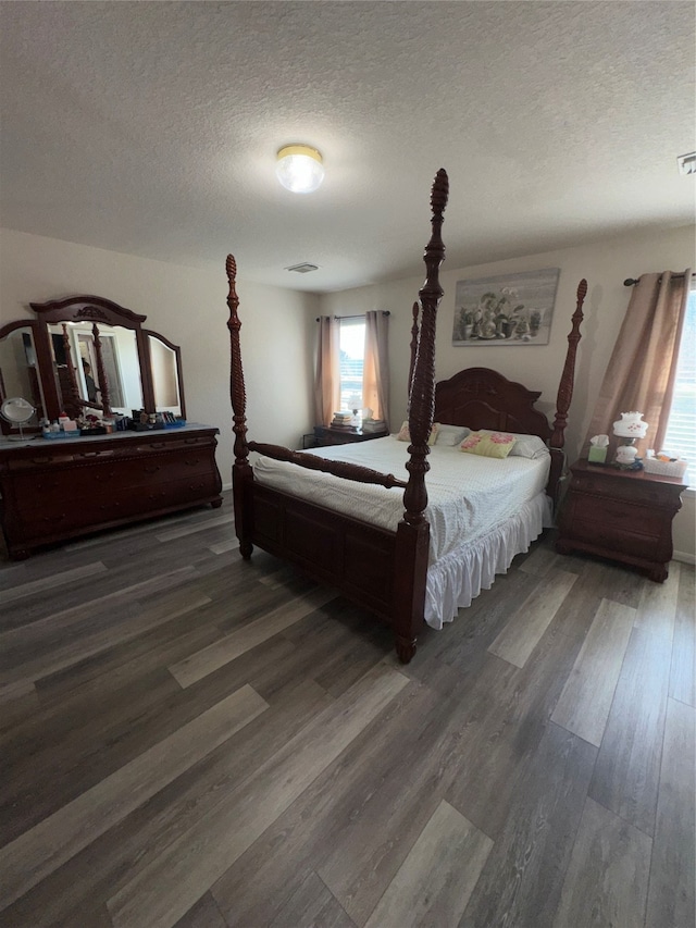 bedroom featuring a textured ceiling and dark wood-type flooring