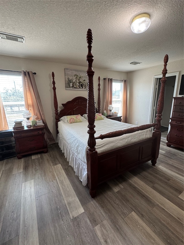 bedroom with hardwood / wood-style floors and a textured ceiling