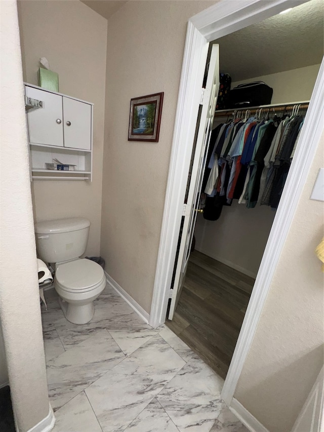 bathroom featuring hardwood / wood-style flooring and toilet