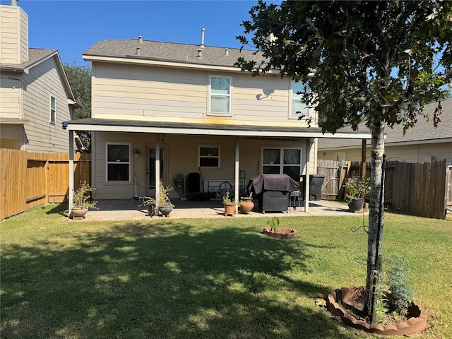 rear view of house with a patio and a lawn