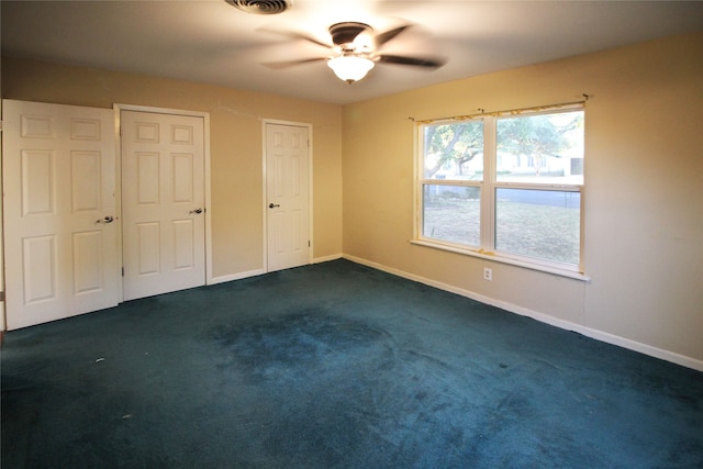 unfurnished bedroom featuring dark colored carpet and ceiling fan