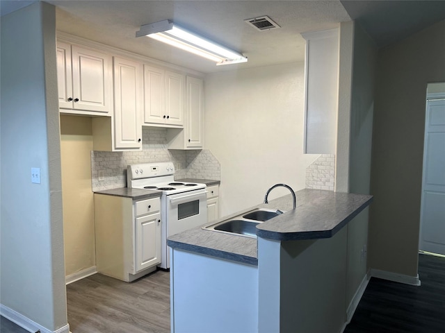 kitchen featuring white electric range, white cabinetry, wood-type flooring, sink, and kitchen peninsula