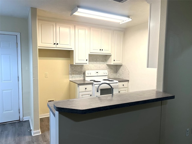 kitchen featuring white cabinetry, backsplash, white electric range oven, dark hardwood / wood-style flooring, and kitchen peninsula