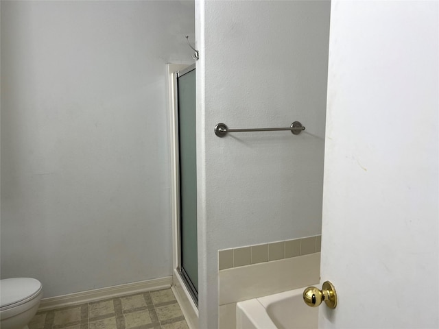 bathroom with a shower with shower door and toilet