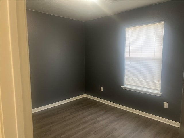 empty room with dark hardwood / wood-style flooring