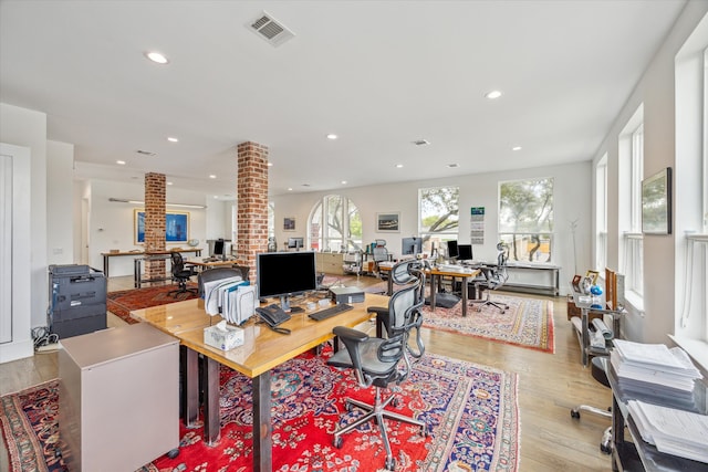 office area featuring light hardwood / wood-style floors and decorative columns