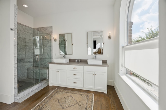 bathroom with a wealth of natural light, a shower with door, hardwood / wood-style flooring, and vanity