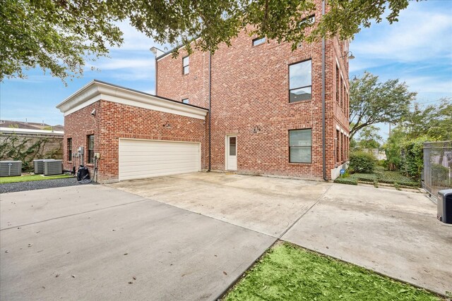 exterior space with cooling unit and a garage