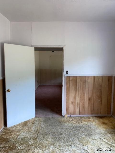 carpeted empty room with wainscoting