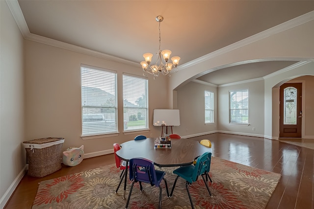 dining space with ornamental molding, a chandelier, and dark hardwood / wood-style flooring