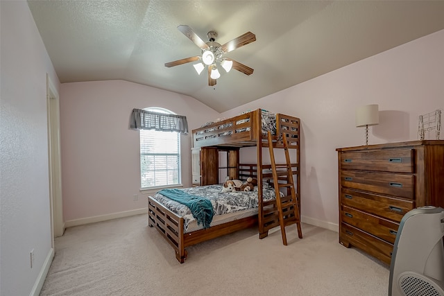 carpeted bedroom featuring lofted ceiling, a textured ceiling, and ceiling fan