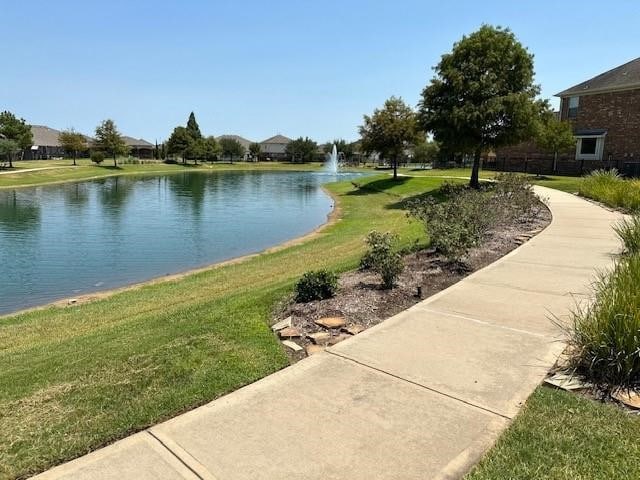 view of home's community featuring a water view and a lawn