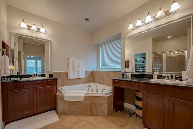 bathroom with tile patterned floors, vanity, and shower with separate bathtub