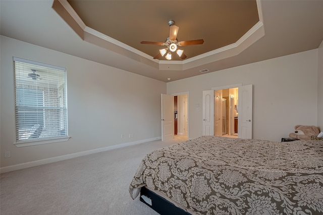 bedroom featuring light carpet, a tray ceiling, ornamental molding, and ceiling fan