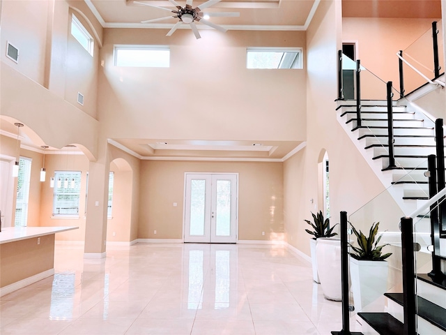 tiled foyer with french doors, crown molding, a high ceiling, and ceiling fan