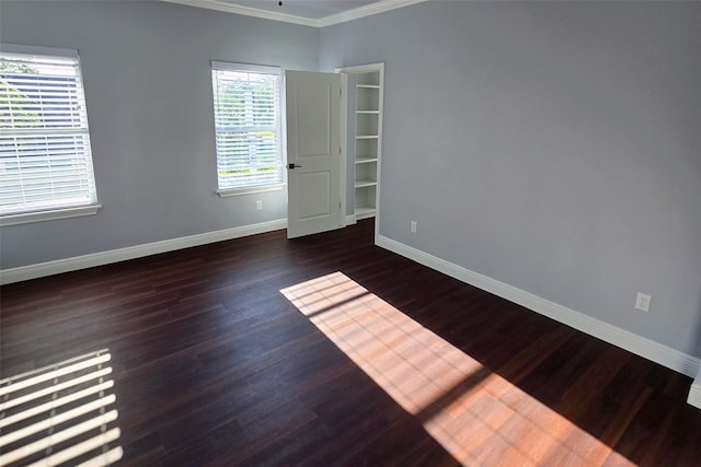 spare room featuring crown molding and dark hardwood / wood-style flooring