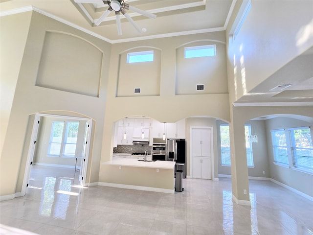 living room with ceiling fan, crown molding, plenty of natural light, and sink