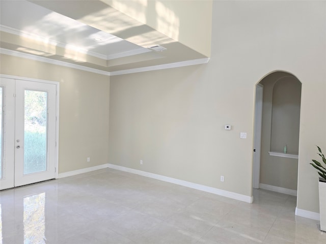 unfurnished room featuring crown molding, french doors, and a raised ceiling