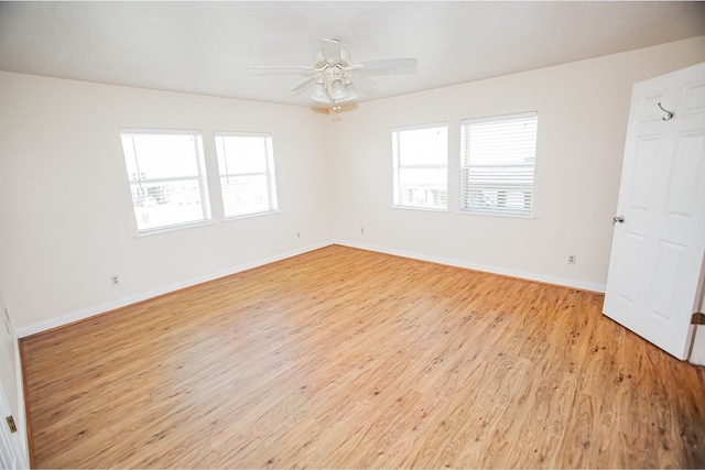 empty room featuring plenty of natural light, light wood-type flooring, and ceiling fan