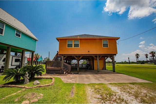 rear view of house featuring a yard and a carport