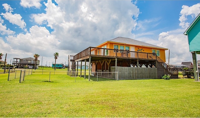 rear view of house featuring a lawn and a deck