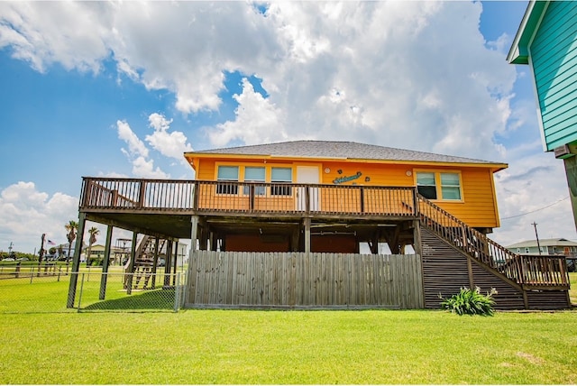 rear view of house featuring a wooden deck and a lawn