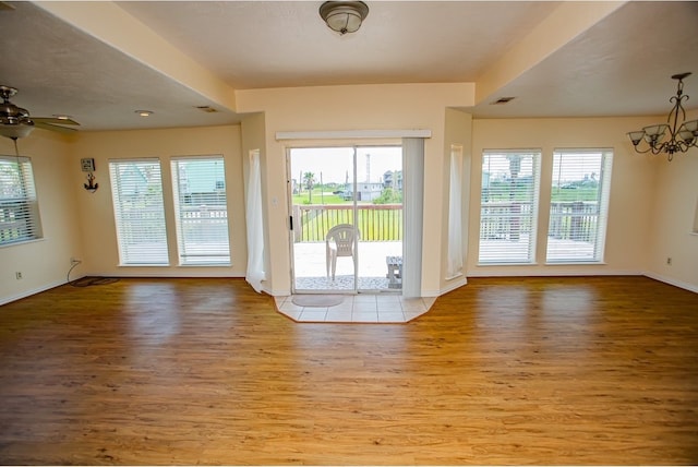 entryway with ceiling fan with notable chandelier and light hardwood / wood-style floors