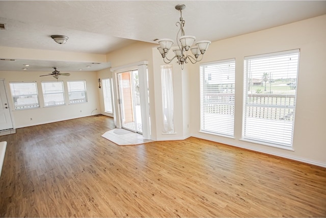 interior space with ceiling fan with notable chandelier and light hardwood / wood-style floors