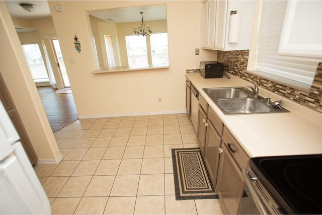 kitchen with decorative backsplash, a wealth of natural light, hanging light fixtures, and sink