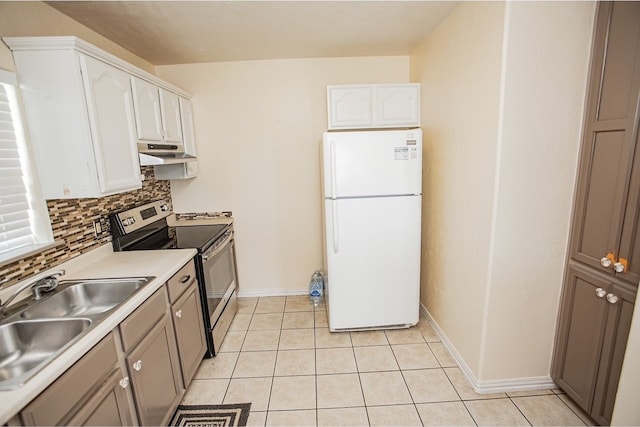 kitchen featuring white cabinets, sink, tasteful backsplash, stainless steel range with electric cooktop, and white fridge