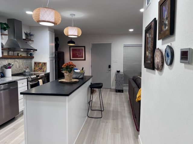 kitchen with dark brown cabinetry, tasteful backsplash, extractor fan, hanging light fixtures, and appliances with stainless steel finishes