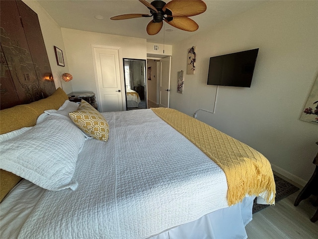 bedroom featuring hardwood / wood-style flooring, ceiling fan, and a closet